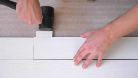 close-up. male hands install white laminate indoorsの写真素材