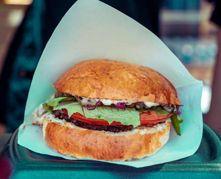 Juicy burger cooked at barbecue outdoors in craft paper. Cookout american bbq food. Street food, fast food.の写真素材