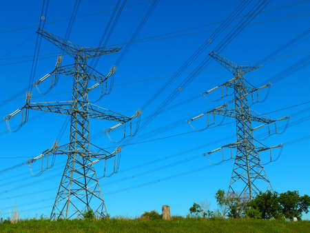 Electric post in a field and blue skyの写真素材