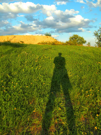 Man shadow on a grass field 