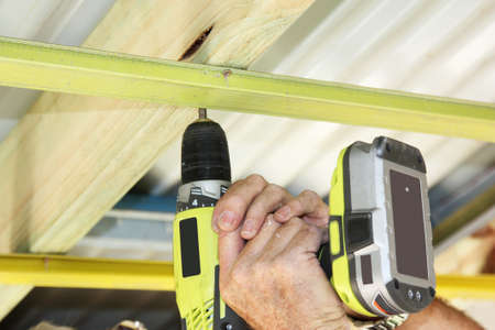 a cordless hand drill used to put ceiling battens