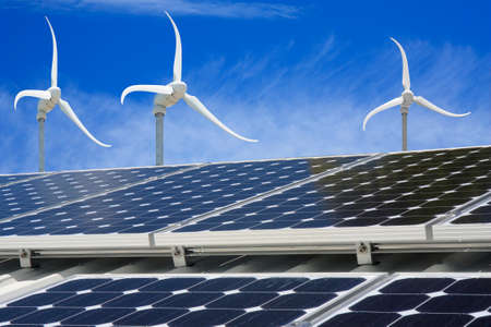 solar panel on a house with wind generators in backgroundの写真素材