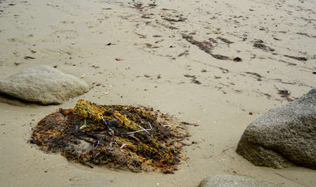 old abandoned sea fishing nets laying on the beachの写真素材