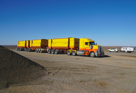 Long yellow Road Train or long combination vehicle for moving freight.