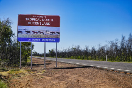 A vibrant welcome sign for Tropical North Queensland, welcomes visitors set against a blue sky and open landscape.の写真素材