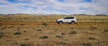 The Painted Desert a 4x4 travels on a desolate desert plain evoking adventure, travel, and exploration.Area is notable for its distinctive mesas, mountains, and geological formations.の写真素材