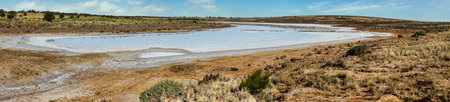 National Hwy, Oakden Hills SA a vast arid scene with salt flats, dry earth, and low scrub under a bright blue sky. Ideal for nature, travel, and outdoor adventure themes.の写真素材