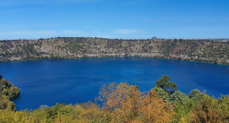The Blue Lake is situated near Mount Gambier in the Limestone Coast region of South Australia, and is one of four volcanic crater lakes . Bright turquoise water of Blue Lake in Mount Gambier shines against a green landscape.の写真素材