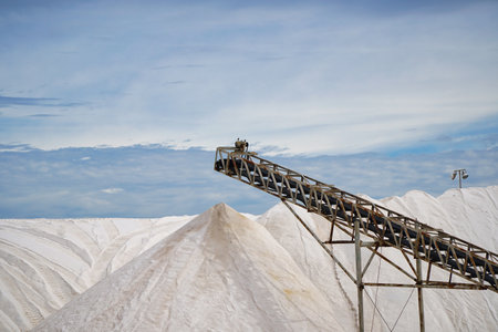 Large mounds of salt are stacked at a refinery in Thevenard. A conveyor system is used to transport the salt. The scene captures the scale and operations of this salt production facility. Eyre Peninsula in South Australiaの写真素材