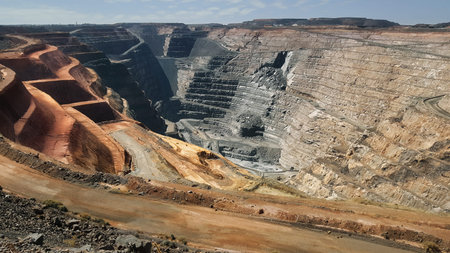 Kalgoorlie, massive open-pit mine seen from above with terraced benches, haul roads and exposed rock...