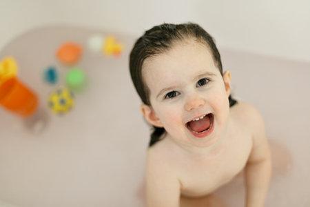 Bath time with laughing toddler in family bathroomの写真素材