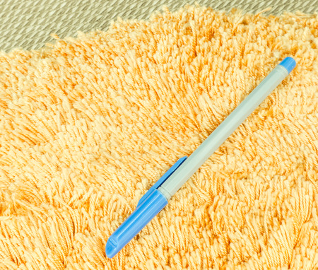 Blue Pen on Orange Hair Fur Carpet on a Matの写真素材