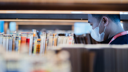 "Jakarta, Indonesia - October 2022: an asian man is looking for a book in the aisle of the Jakarta library bookshelf."のeditorial素材