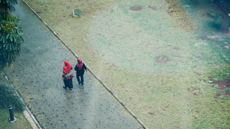 Jakarta, Indonesia - October 2022: two women wearing hijabs are walking towards somewhere in the...