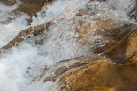 water fall. River on the white background. Stream flowing fast over rocks. Beautiful veil cascading waterfall, mossy rocksの写真素材