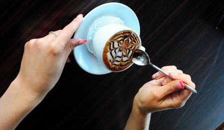 Cup of cappuccino. Beautiful female hands