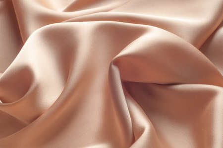 tissue, textile, cloth, fabric, material, texture. beige color. cloth, typically produced by weaving or knitting textile fibers.の写真素材