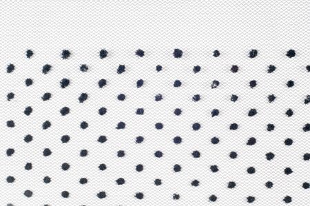 Lace on black and white fabric. a fine open fabric, typically one of cotton or silk, made by looping, twisting, or knitting thread in patterns and used especially for trimming garments.の写真素材