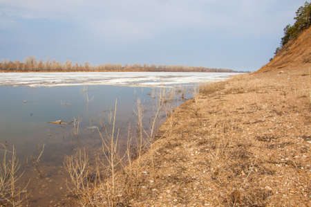 Spring River, the ice on the river. picturesque spring landscape with river ice melted bare trees and beautiful clouds in the blue skyの写真素材