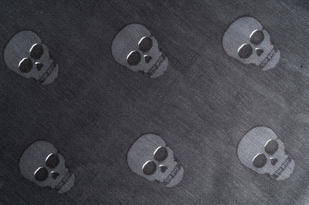 The texture of the silk fabric in black with small skulls pirateの写真素材