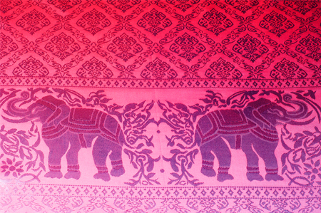 elephant silk fabric, texture, Closeup pattern of elephant and tree on thai silk fabric. India. traditional Thailand batik sarong with pattern elephant.の写真素材