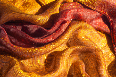 The texture of wool fabric yellow red golden. Women's scarf, the perfect backdrop.  cravat, neckerchief, kerchief, muffler, throw. a length or square of fabric worn around the neck or head.の写真素材