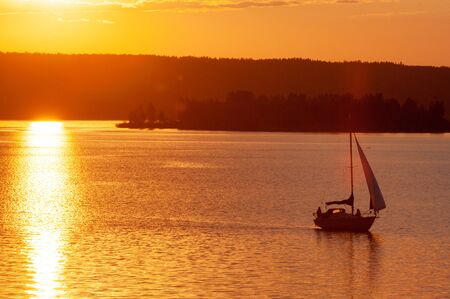 Sunset on the water, sunrise on the water, a boat in the sunの写真素材