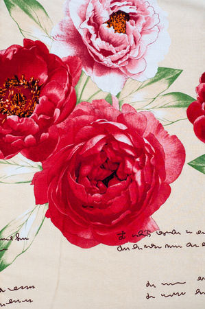 Texture, background, fabric cotton bed linen, bright red flowers on a beige backgroundの写真素材