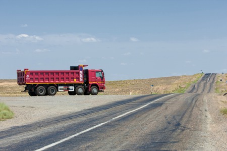 editorial. Kazakhstan. Balkhash. June 1, 2014. Road in the desert. The road in the summer. Beautiful bend of the road. Chinese car "Sinotruk"  HOWO ZZ3537N28D7Bのeditorial素材