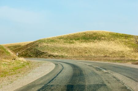 Country road in spring. road winds between hillsの写真素材