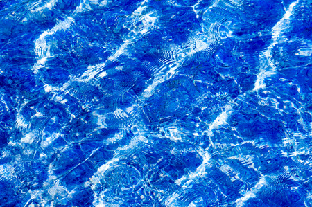 Texture background. Texture background. The water in the pool is photographed in counter light. The glare from the sun on the wavesの写真素材