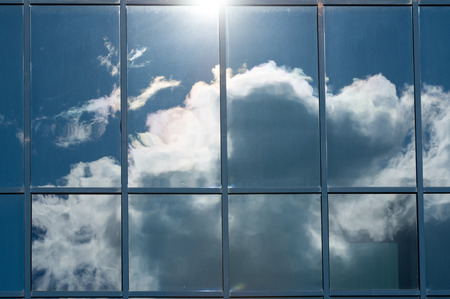 Texture, pattern, background. Reflection in building windows. Blue windows, clouds reflected in the...