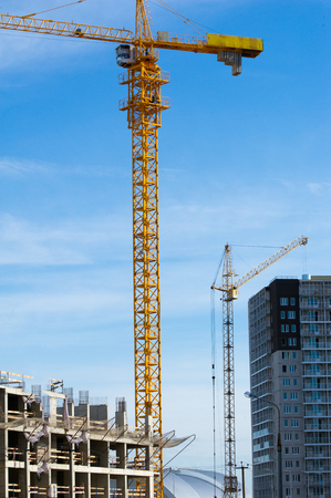 Texture, pattern, background. Tower cranes on the construction of residential buildings, painted with yellow paintの写真素材