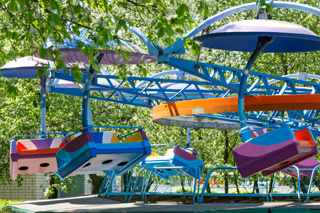 Atraktsion children's carousel. A rotating device for driving in a circle with the seats in the form of chairsの写真素材