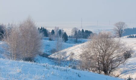 Winter landscape. Frost frost on the trees. Mist evaporation of water. Blue sky. Sunny day. Opaque air saturated with water vapor, filled with bright light of the sunの写真素材