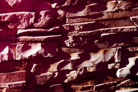 Texture, background, pattern. Natural stone lined wall. Hard rock chunks or solid mass, as well as a piece, vertical part of the building premises.の写真素材