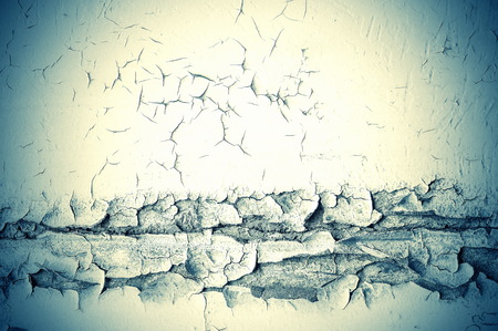 Texture, pattern, background. old paint. Concrete wall cracked paint, paint abstractly behind the concrete. With white tone paint flakes off over timeの写真素材