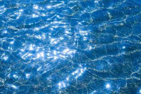 Texture background.  The water in the pool is photographed in counter light. The glare from the sun...