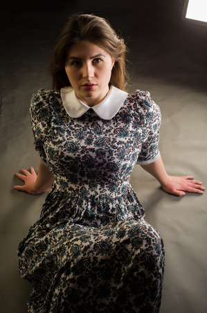 girl kneeling. Pretty woman on all fours. Photo-session in studio of the young girl, on all fours. to grabble. sidewaysの写真素材