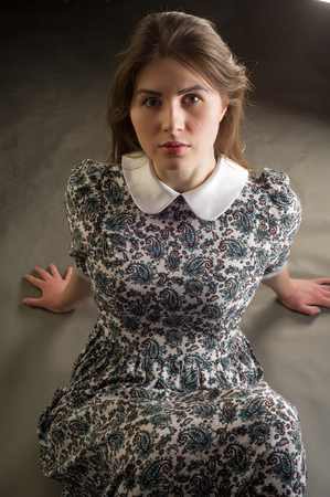 girl kneeling. Pretty woman on all fours. Photo-session in studio of the young girl, on all fours. to grabble. sidewaysの写真素材