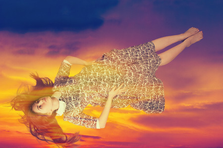 Girl flying in a dream. a series of thoughts, images, and sensations occurring in a person's mind during sleep.の写真素材