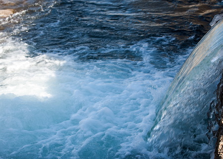 Streaming water in a small river at early springtime. Spring scene.  Mountain landscape with a frozen creekの写真素材