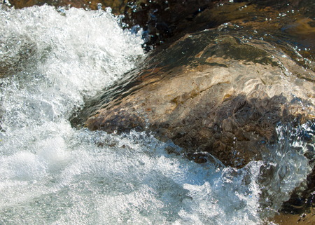 Streaming water in a small river at early springtime. Spring scene.  Mountain landscape with a...