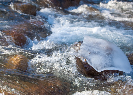 Streaming water in a small river at early springtime. Spring scene.  Mountain landscape with a...