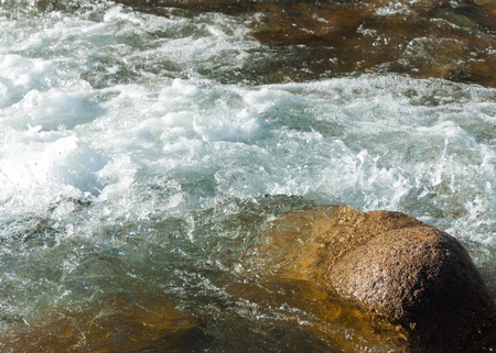 Streaming water in a small river at early springtime. Spring scene.  Mountain landscape with a frozen creekの写真素材