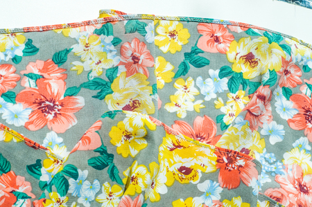 Texture, background, pattern. Girl's skirt. Silk fabric with floral pattern. Red Yellow Flowers