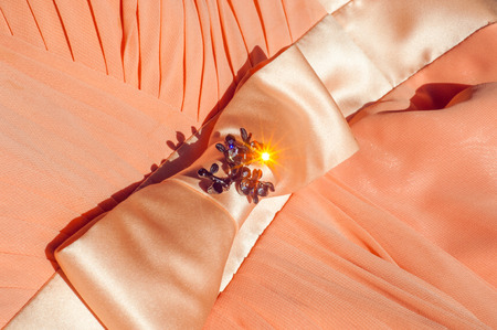 Texture, background, pattern. A dress of light orange color, a silk ball gown. Fabric coral silkの写真素材