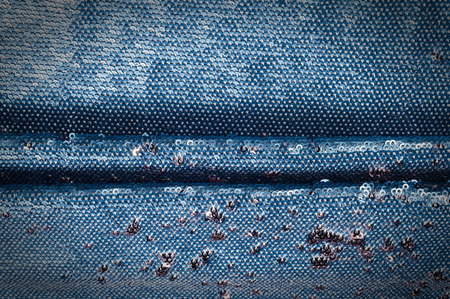 Texture, background, pattern. Silk fabric of blue color embroidered with sequins, sparkles reflects the rays of the sunの写真素材