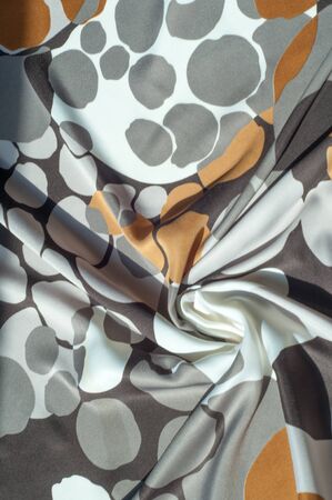 Texture, background, pattern. Abstract pattern on a silk fabric, white yellow brown circles