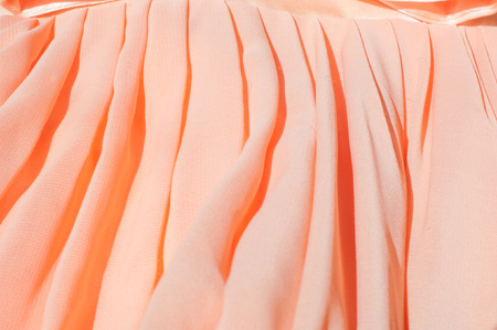 Texture, background, pattern. A dress of light orange color, a silk ball gown. Fabric coral silkの写真素材